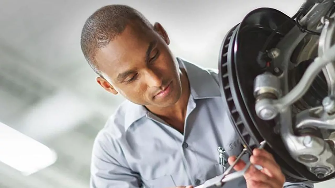 Audi service technician servicing a vehicle.