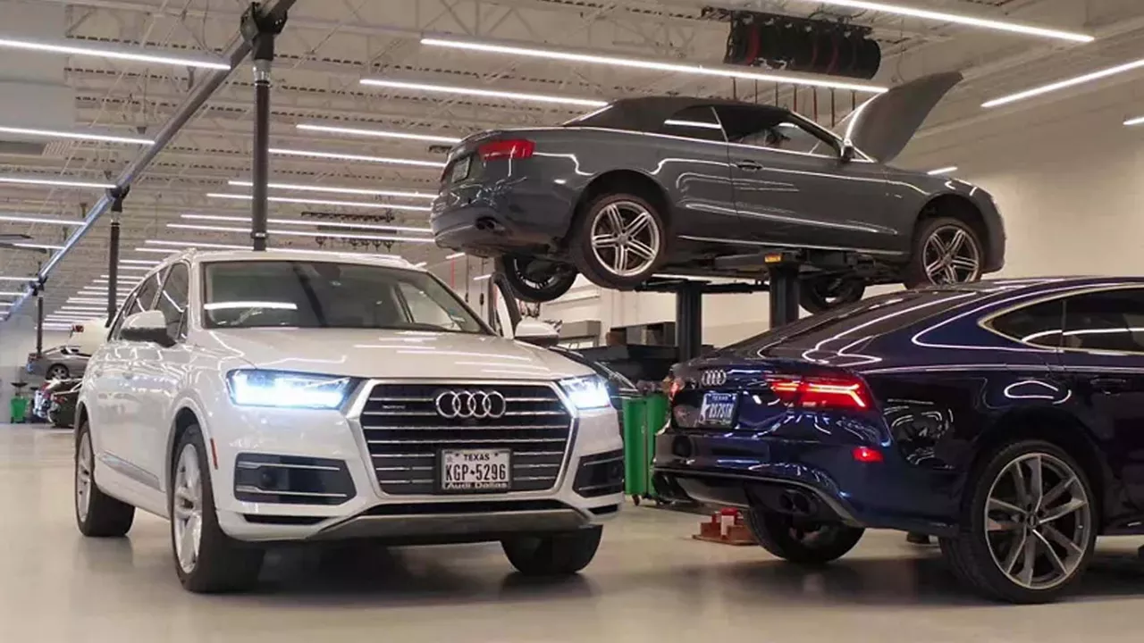 Three Audi vehicles parked in an Audi Service center.