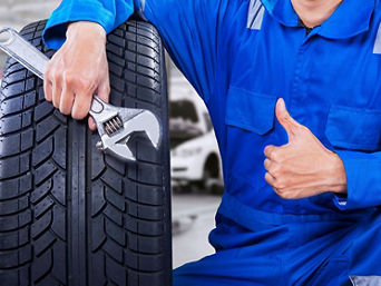 Service technician servicing tire.