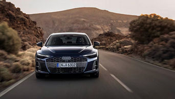 Front view of the 2026 Audi A6 Sedan driving on the road.