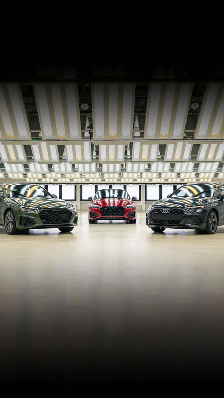 Trois véhicules Audi stationnés face à face.