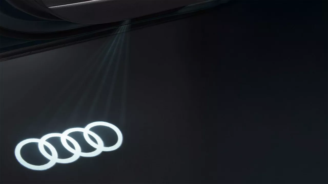 Audi rings being shone on a black background.