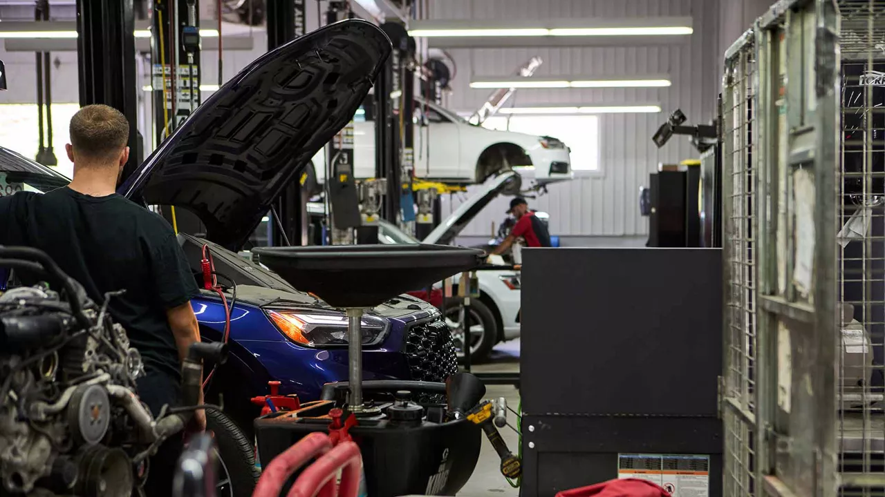 Two service technicians servicing Audi vehicles.