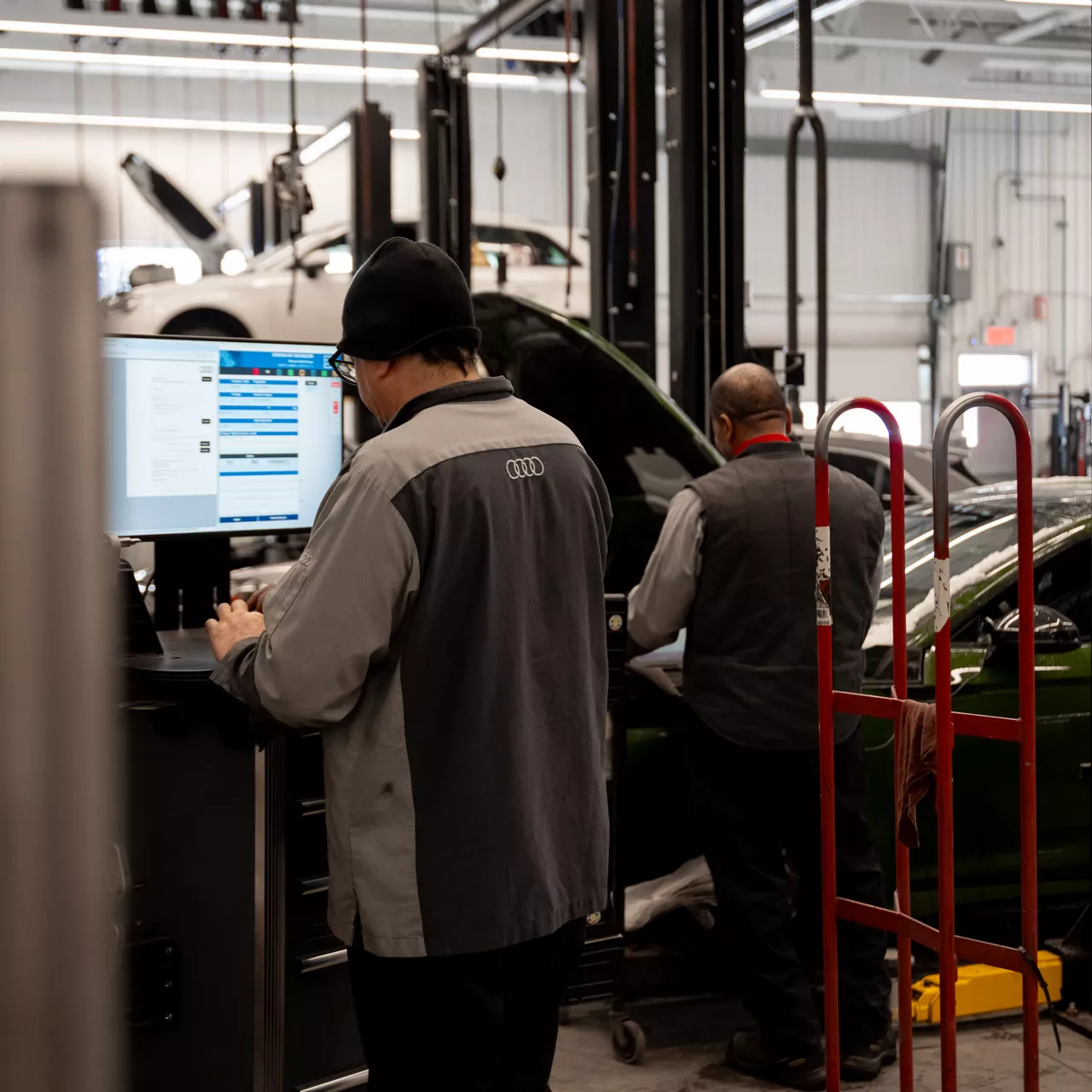 Un technicien du service Audi effectue l’entretien d’un véhicule.