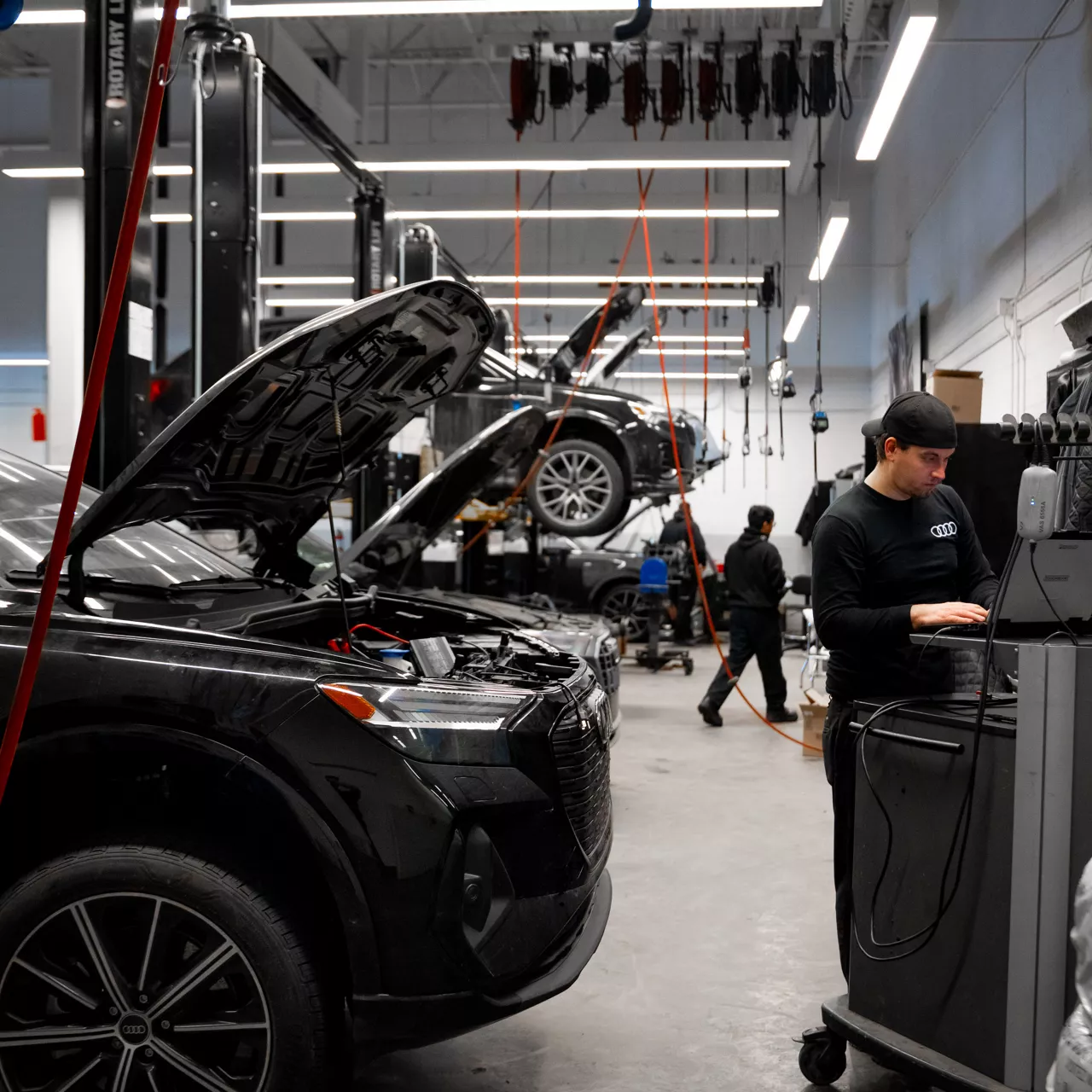 Un technicien du service Audi effectue l’entretien d’un véhicule.