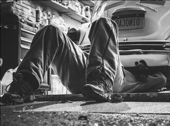 Service technician servicing vehicle.