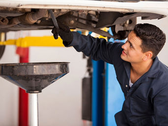 Service technician repairing vehicle.