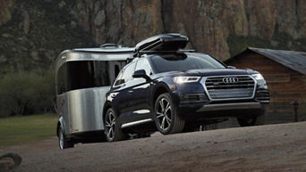 Audi vehicle parked with a hitch attached.