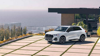 Three quarter profile view of an Audi Q3 parked.