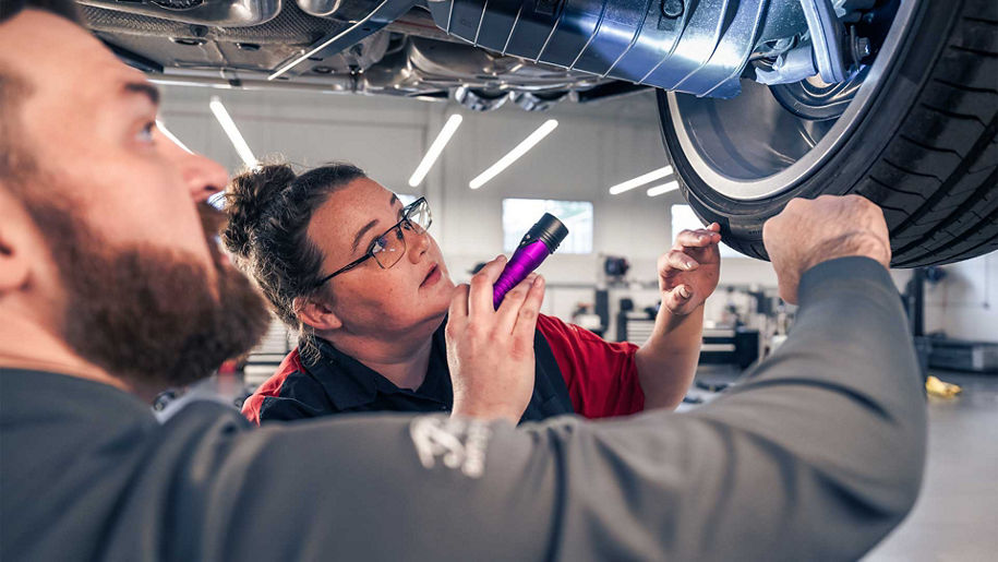 Audi service technician inspecting a vehicle