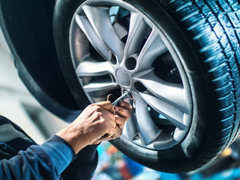 Service technician servicing tire.