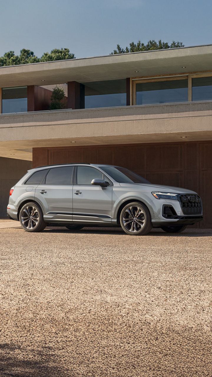 Side profile shot of the 2025 Audi Q7 parked in front of building.