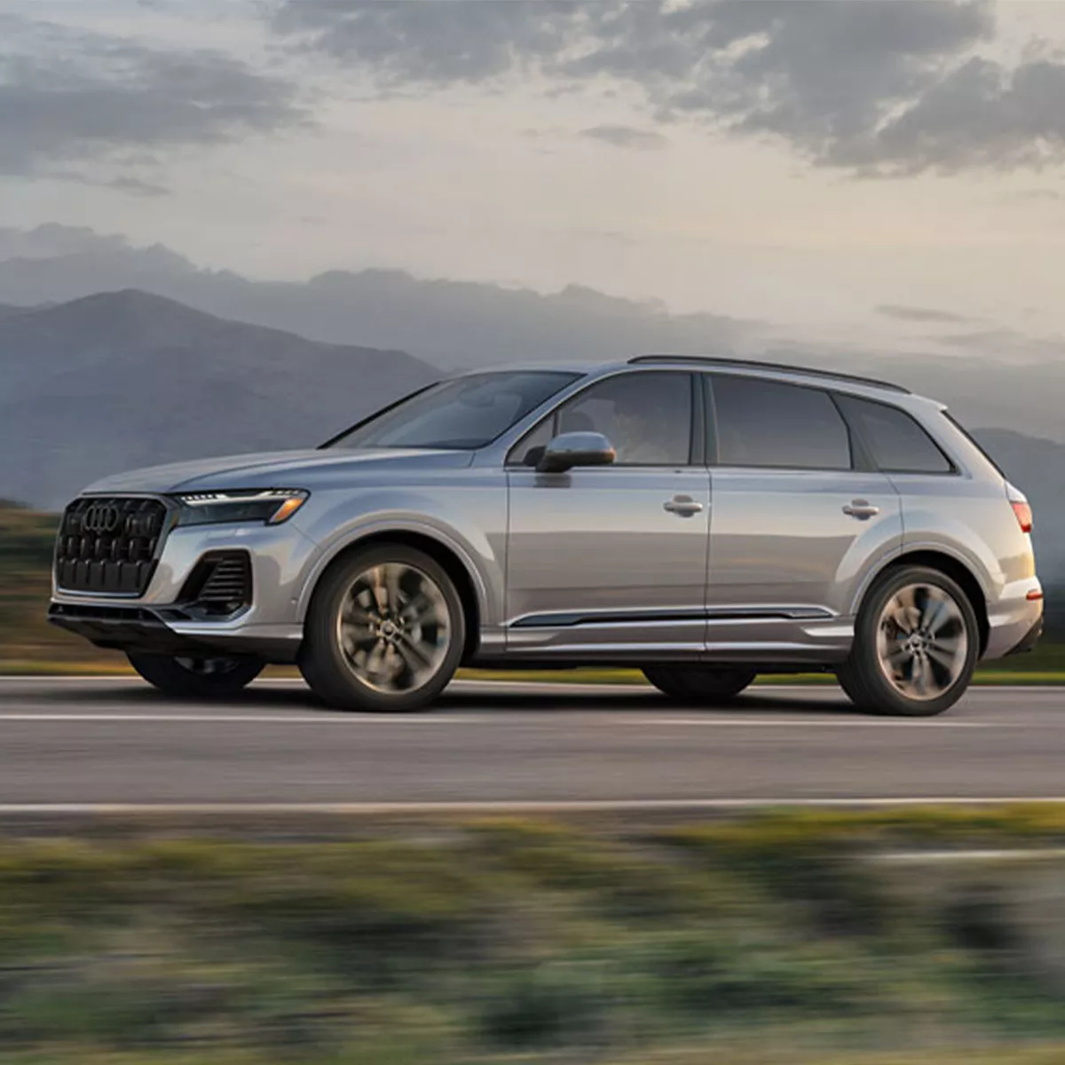 Side profile shot of the 2025 Audi Q7 driving on mountainous road.