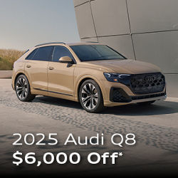 Three quarter profile view of an Audi Q8 parked.