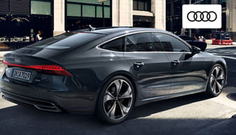  Side view of a 2024 Audi A7 driving along a scenic route near Dayton, showcasing its aerodynamic fastback profile. 