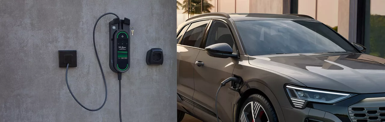 Audi SUV plugged into a wall mounted electric vehicle charger