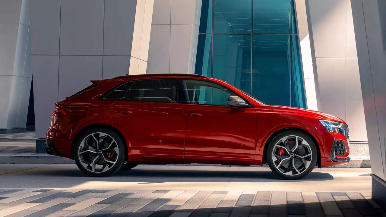 Side view of an Audi vehicle parked outside of a building.