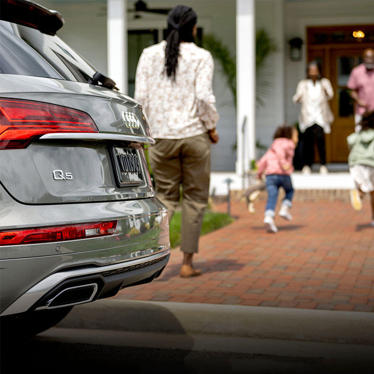 Close-up of the tail light and bumper of an Audi Q5 parked outside of a house.