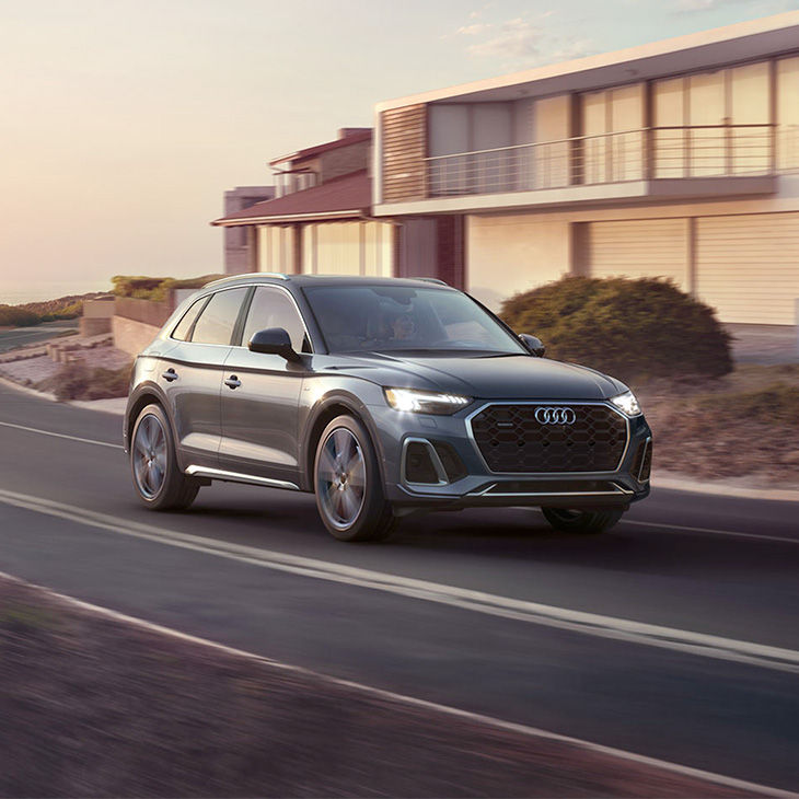 Three-quarter front view of an Audi vehicle on the road.