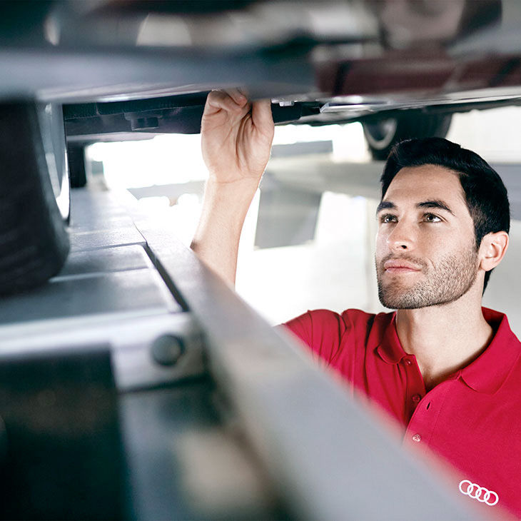 An Audi Technician inspecting a vehicle.