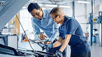 Two people inspecting a vehicle
