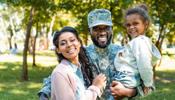 Man in uniform with wife and child.