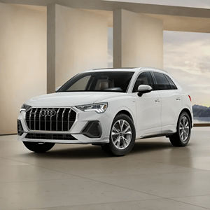Front 3/4 view of a white Audi Q3 parked in a modern building