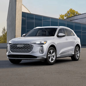 Front 3/4 view of a silver Audi Q5 parked outside a modern building