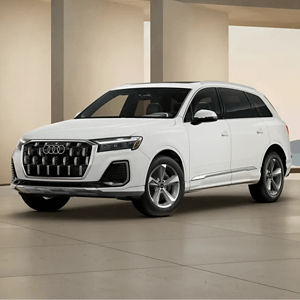 Front 3/4 view of a white Audi Q7 parked in a modern building
