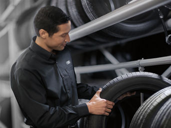Service technician servicing tire.