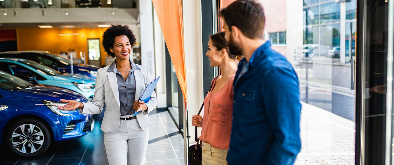 Young couple being welcomed into an Audi model showroom