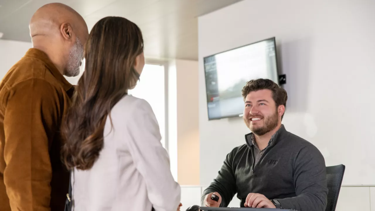 Audi Employee chatting with a couple.