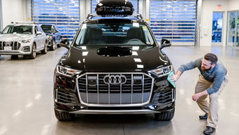 Service advisor wiping down car