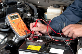 Service technician servicing vehicle with hood open.