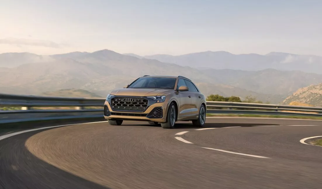 New 2025 Audi Q8 SUV making turn on a hill road