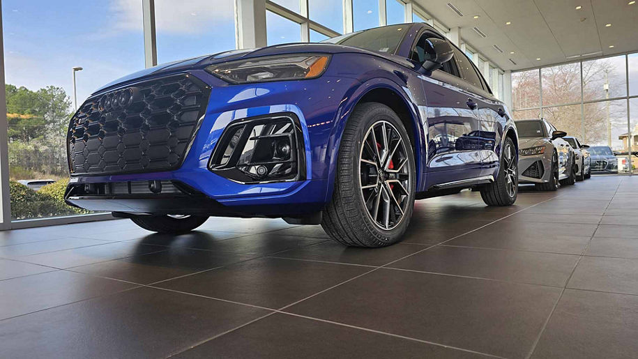 Front profile view of an Audi vehicle parked in the showroom. 