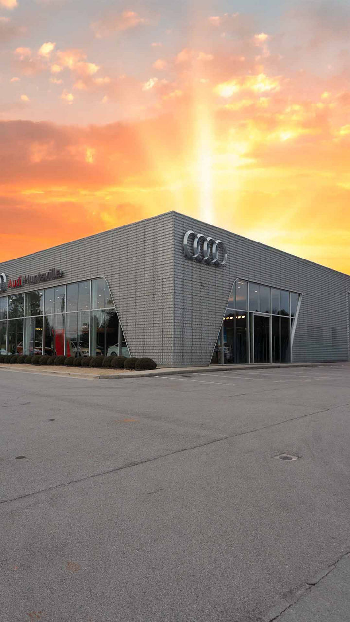 Front profile view of the Audi Huntsville dealership in the sunset.