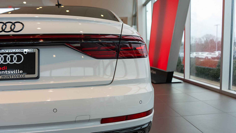 Rear profile view of an audi vehicle parked in the showroom.