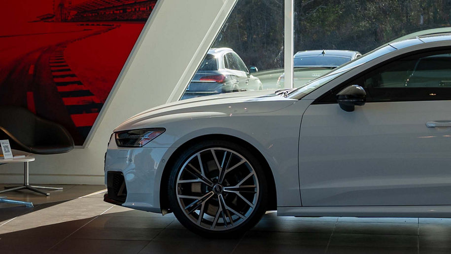 Left profile view of an Audi vehicle parked in the showroom.