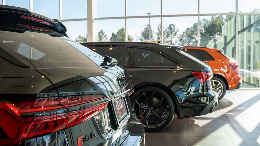 Rear profile view of audi vehicles parked in the showroom.