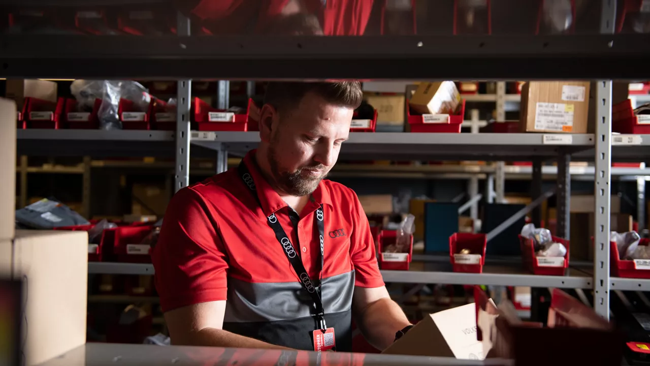 Audi employee handing a set of car keys to a customer.