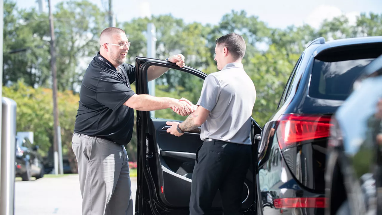 Audi Sale Specialist explaining vehicle features to a customer.