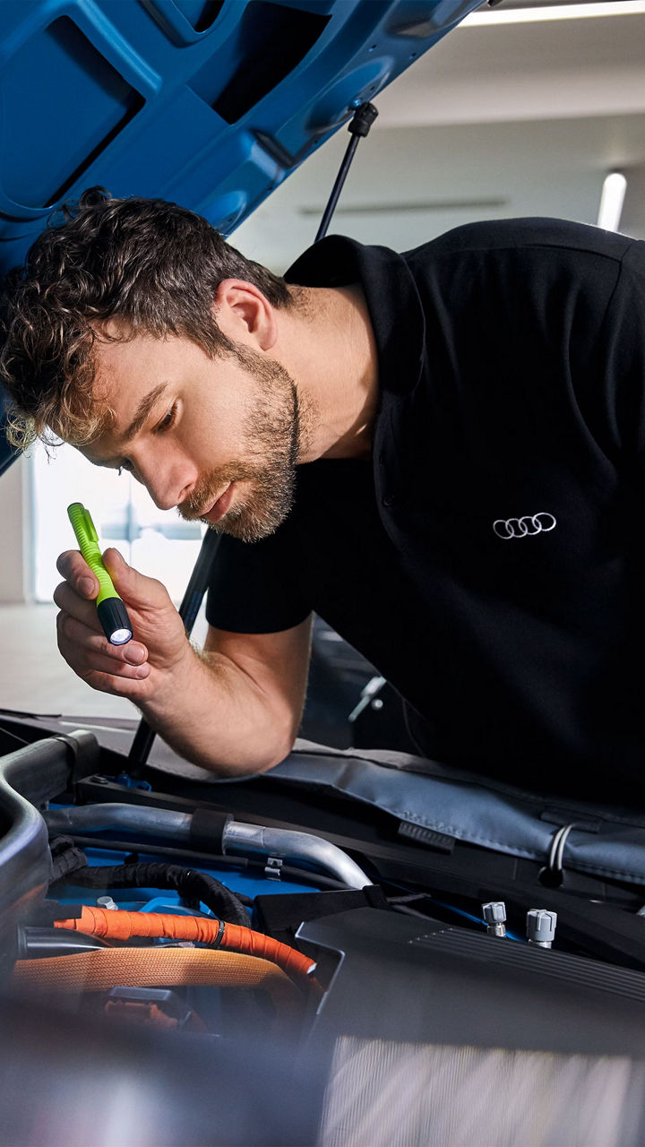 An Audi technician servicing a vehicle.