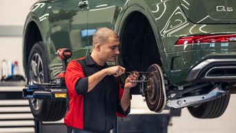 Audi service technician servicing a vehicle.