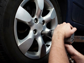Service technician servicing tire.