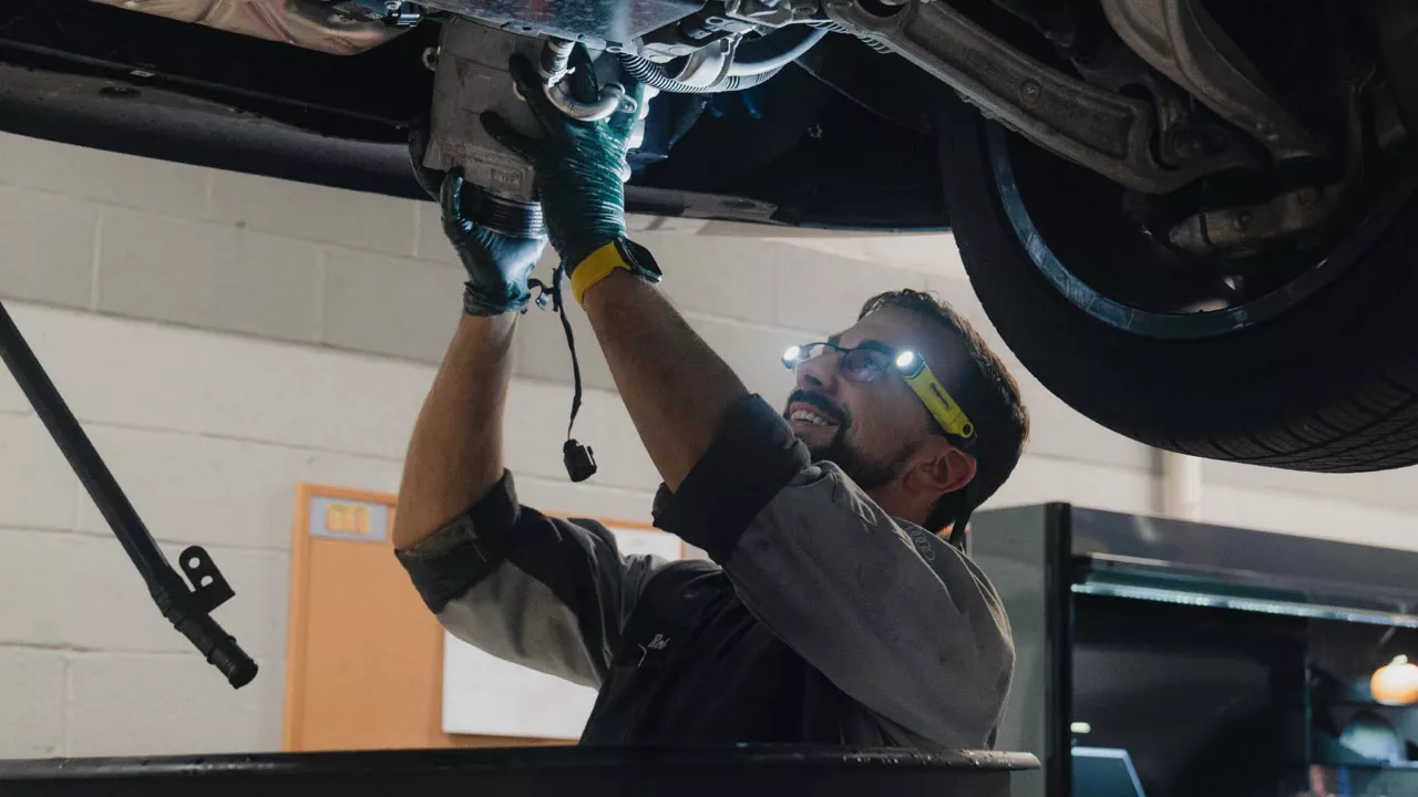 Audi service technician servicing a vehicle.