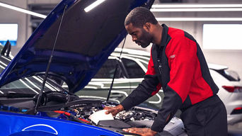 Audi tech doing an oil change to vehicle. 