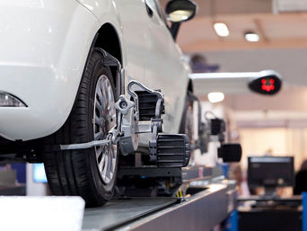Service technician servicing wheel allignment.