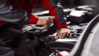 Service technician repairing vehicle.