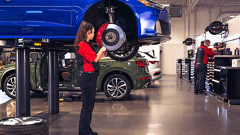 Service advisor inspecting vehicle breaks